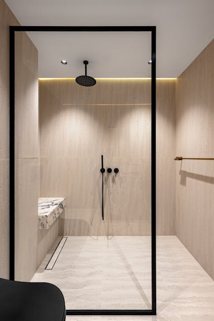 Accueil Sleek walk-in shower with light wood textures and modern fixtures.